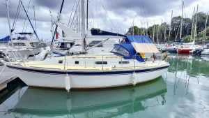 A yacht with a white hull moored by a pontoon