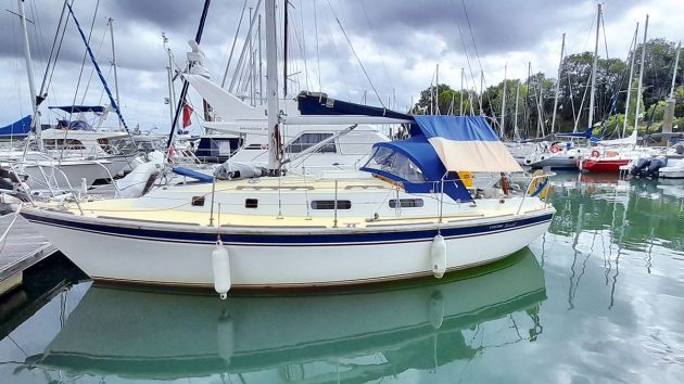 A yacht with a white hull moored by a pontoon