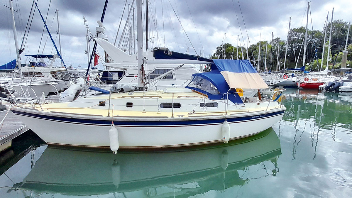 A yacht with a white hull moored by a pontoon