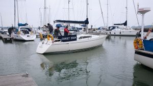 A boat leaving a berth in a marina