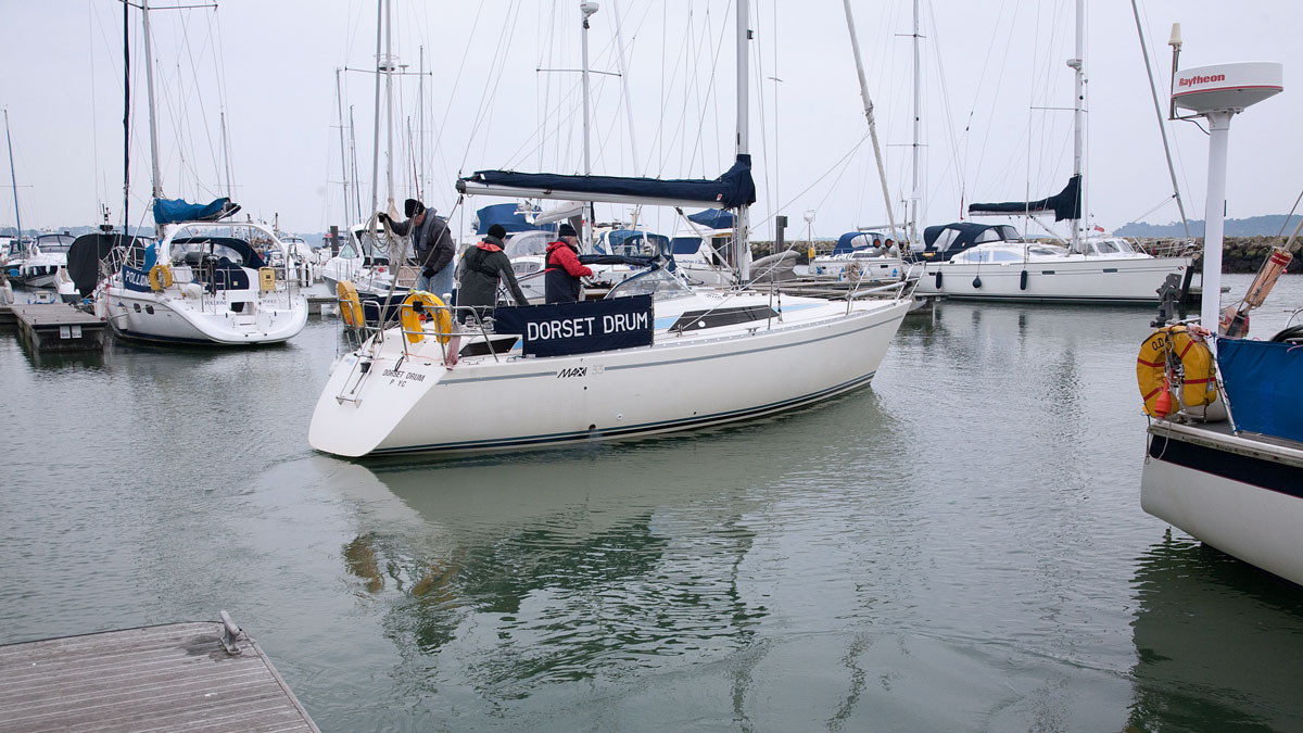 A boat leaving a berth in a marina