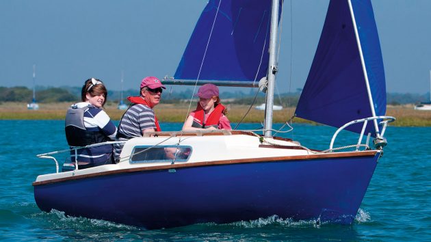 A Voyager yacht being sailed by a man and two girls