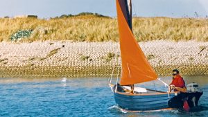 A Hastings Boats with a red sail being sailed
