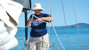 A woman on a yacht sorting out the sailboat lines