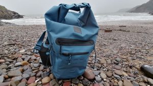 A 30L waterproof backpack on a wet beach