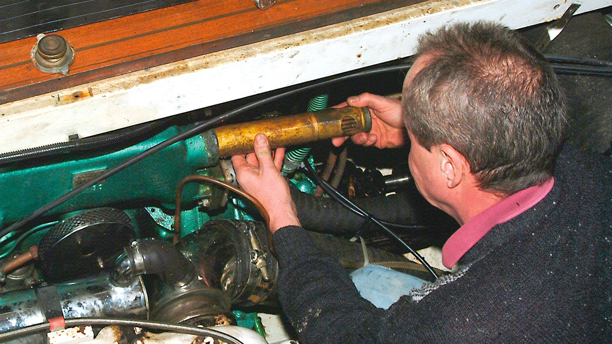 A man servicing a marine engine cooling system