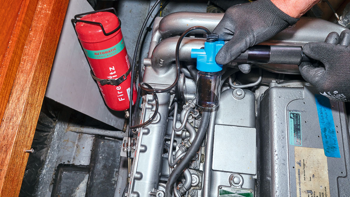 A person drawing oil from a boat engine for an oil test