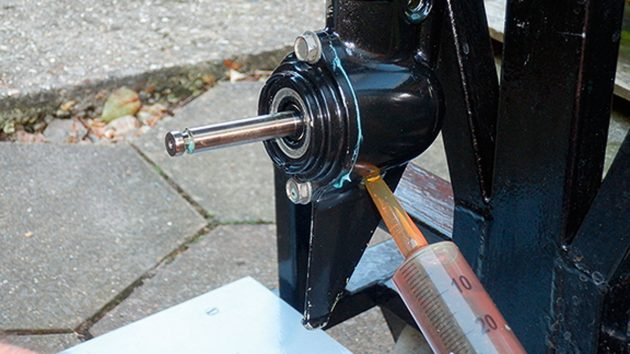 gearbox oil being fed into an outboard motor gearbox