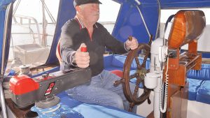 A man using an electric winch handle on his boat