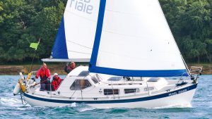A yacht with a white hull and blue and white sails