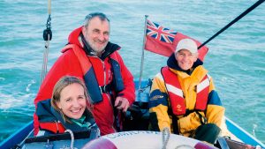 Three people on a boat smiling