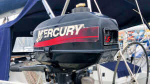 Outboard engine service: a 2-stroke outboard motor hanging from the back of a boat