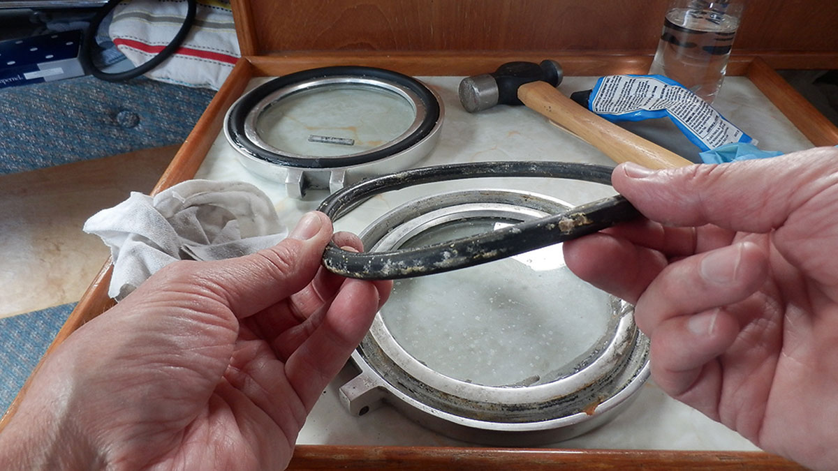 A man replacing a port light seal