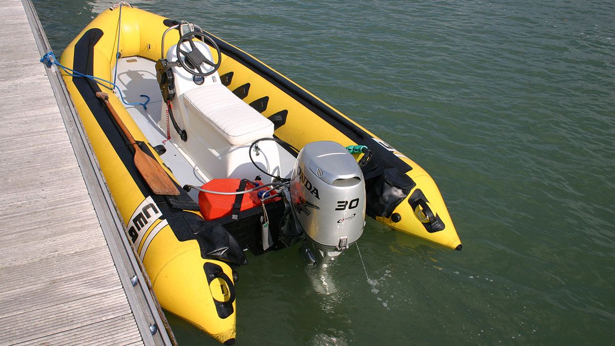 An outboard engine on the back of a yellow RIB
