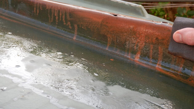 A man cleaning a hull of a boat