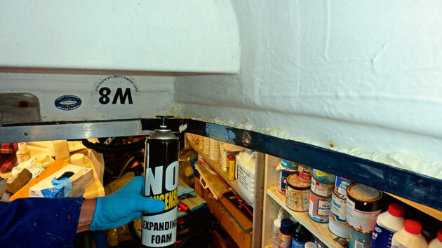 A man spraying expanding foam in a boat