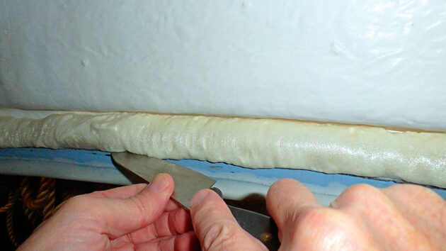 A man using a knife to cut away foam