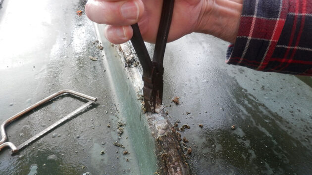 A man using pliers on a boat