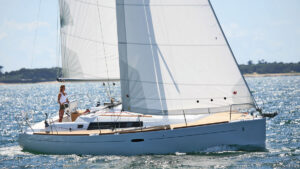 A woman sailing used Beneteau sailboats