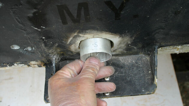 A man fitting pipe to a boat