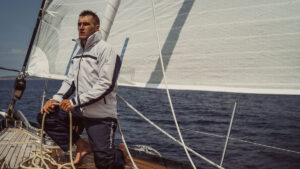 A man wearing a Henri-Lloyd jacket on a boat