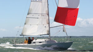 A boat sailing with white and red sails