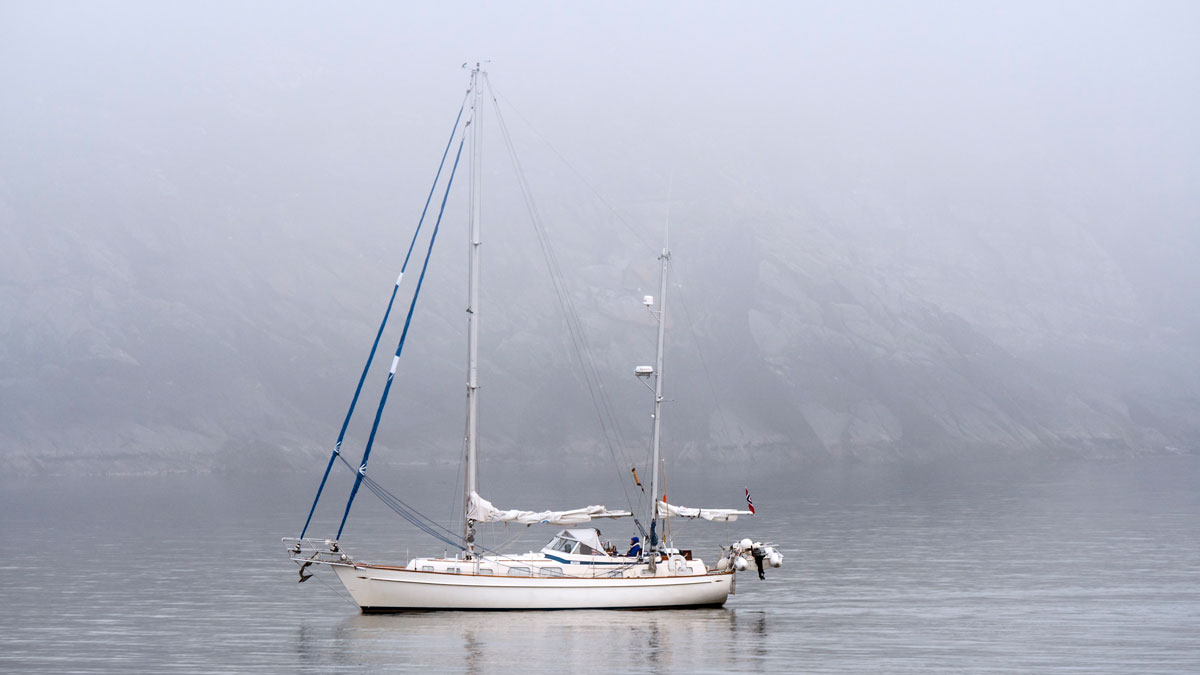 A yacht sailing in fog