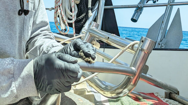 A man cleaning a Monitor windvane steering system