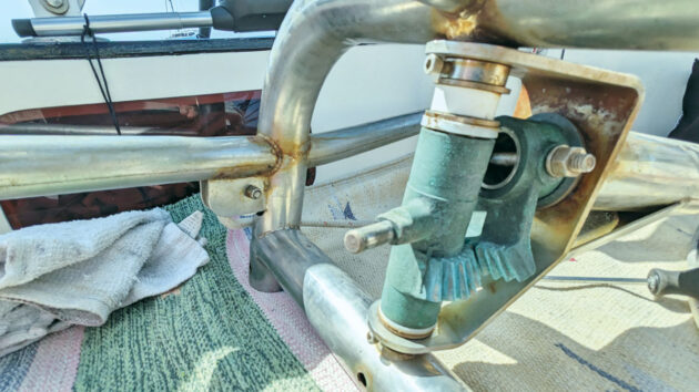 A person servicing a boat's windvane steering system