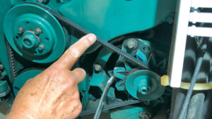 A man alternator belt tensioning on a boat engine