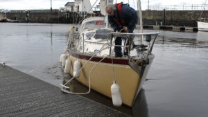 A man on a yacht springing off a pontoon