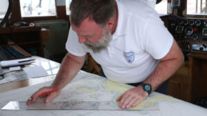 Sailor passage planning on paper navigational chart
