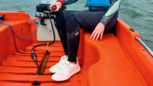 A woman on a boat wearing white Helly Hansen Skagen F2 deck shoes