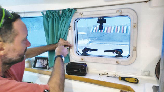 A man removing a boat hatch