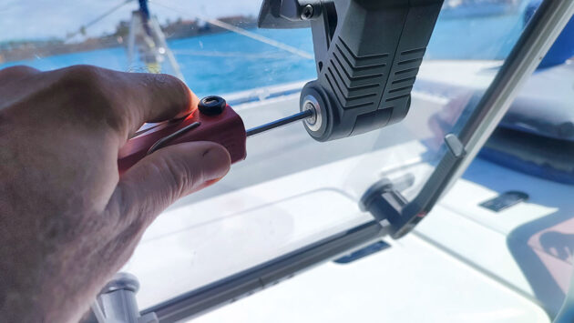 A boat hatch being screwed back into place on a boat