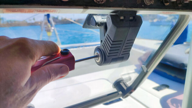 A man unscrewing a screw on a boat hatch