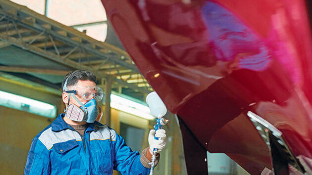 A man spraypainting a boat to give it a mirror finish