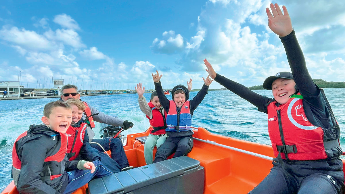 Children cheering on a boat