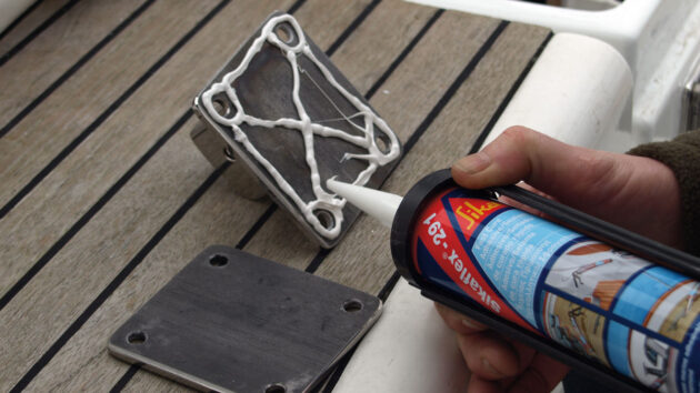 A part of a removable mainsheet track being glued to a boat