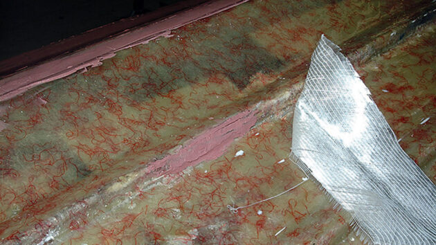 While filling the surface, the worst of the damaged areas and deepest voids on the strakes were also reinforced with strips of biaxial tape pressed onto the tacky surface.