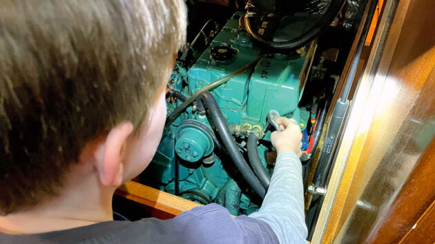 A person working on an exhaust elbow on a boat