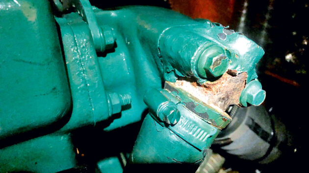 A rusty exhaust elbow on an engine