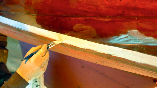 A person varnishing a boat