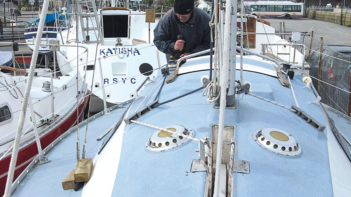 A man using a winch to raise a lifting keel on a boat