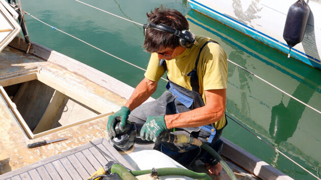 A man sanding the deck of a boat