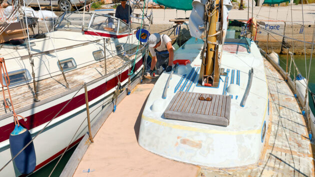A man laying coating of SoftSand anti-skid on the deck of a boat