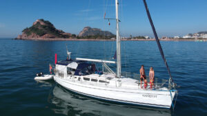 A family standing on the deck of a yacht which they use for bluewater sailing