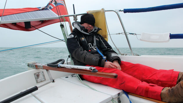 A man sleeping while sailing shorthanded