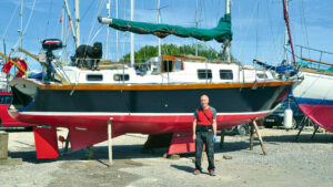 Boat owner Richard Reed with his Seven Summers, a Cruiser Kits Santa Barbara 32 on the hard