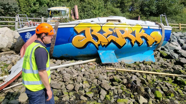A graffiti-painted abandoned boat saying 'berk'. Credit: Langstone Harbour